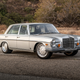A silver 1971 Mercedes-Benz 300SEL 6.3 parked in front of some bushes, front-three quarter view.